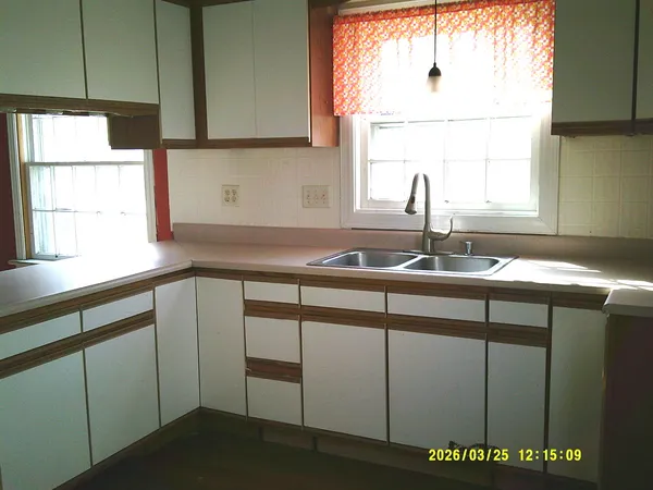a kitchen with a sink cabinets and a window