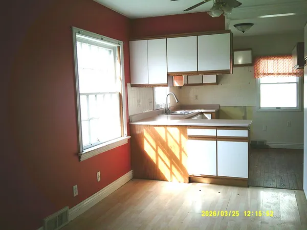 a kitchen with stainless steel appliances granite countertop a sink a stove a washer dryer and a window