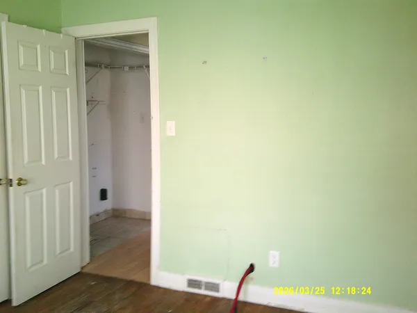 a view of a room with wooden floor and a chair