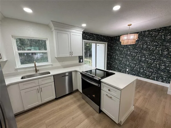 a kitchen that has a sink and a stove in it
