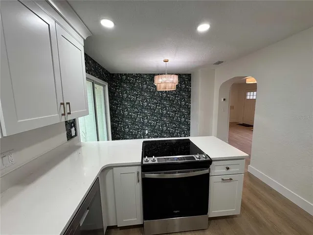 a kitchen with stainless steel appliances kitchen island wooden cabinets and a stove