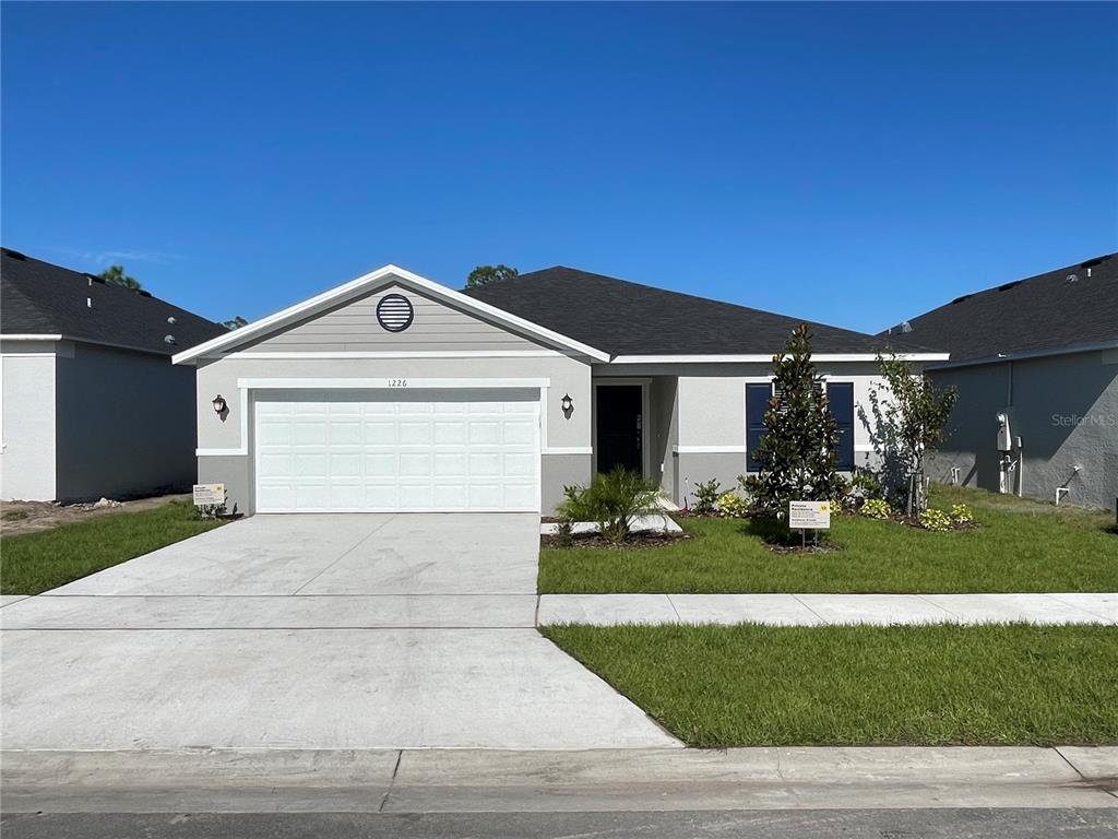 1226 Augustus Drive Davenport, FL 33896 - Photo 1 of 1 a front view of a house with a yard and garage