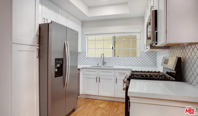 a kitchen with stainless steel appliances granite countertop a refrigerator and a stove