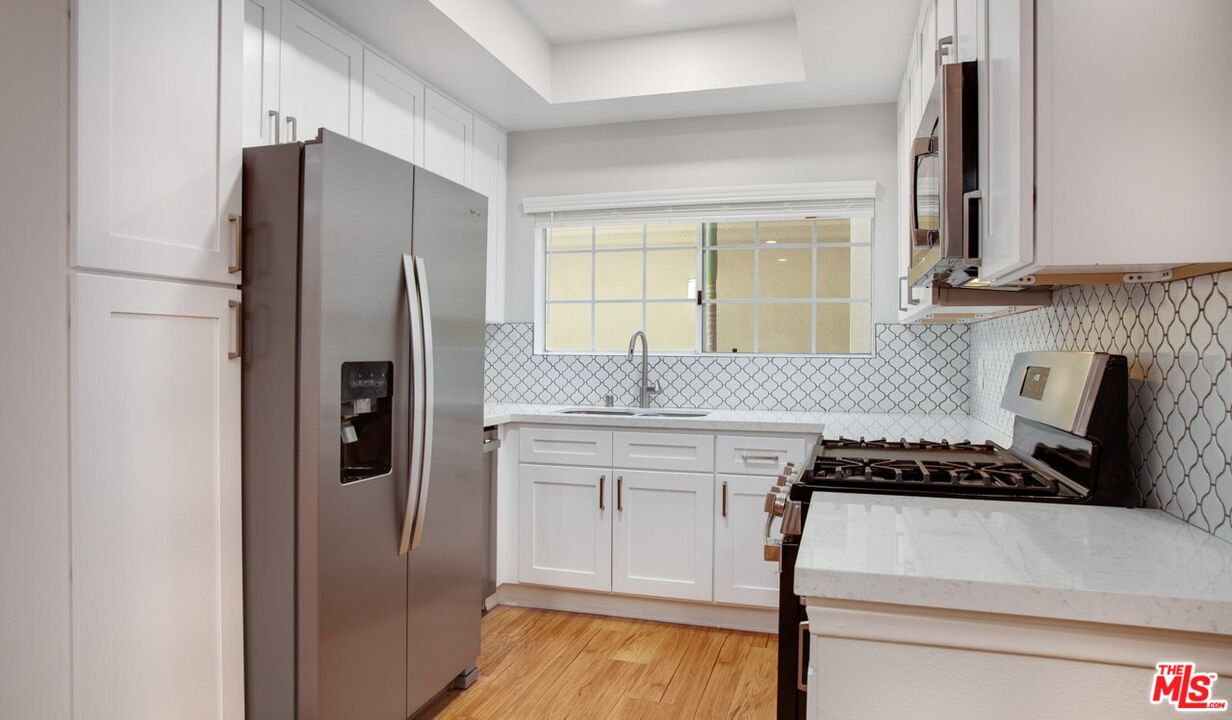 a kitchen with stainless steel appliances granite countertop a refrigerator and a stove