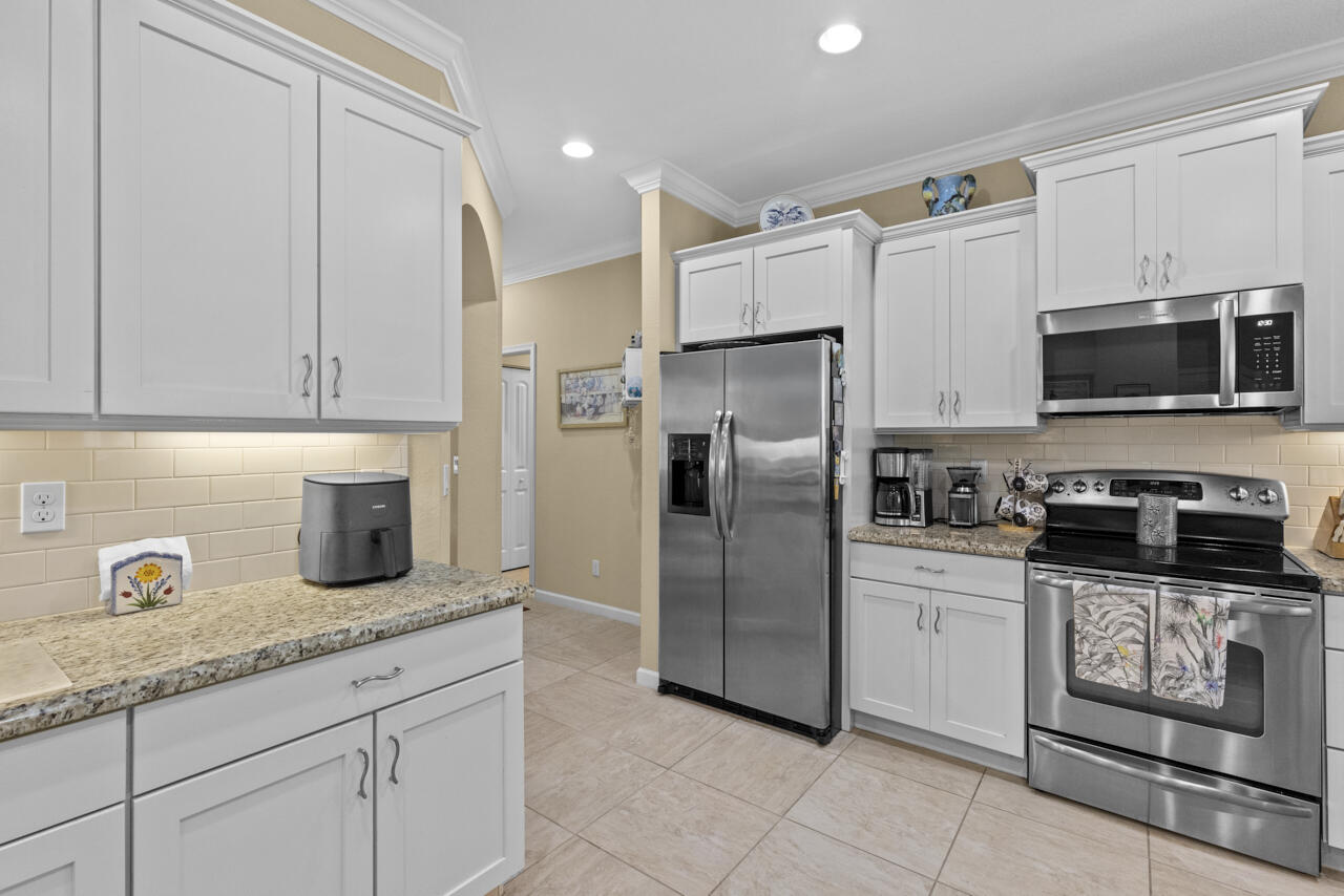 2190 Northwest Dalea Way Stuart, FL 34994 - Photo 15 of 31 a kitchen with granite countertop a refrigerator sink and cabinets