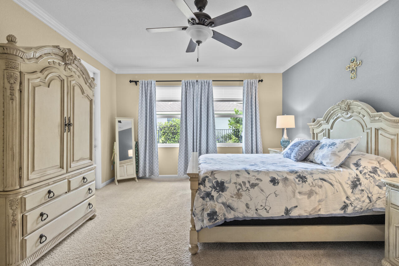 2190 Northwest Dalea Way Stuart, FL 34994 - Photo 17 of 31 a bedroom with a large bed and ceiling fan