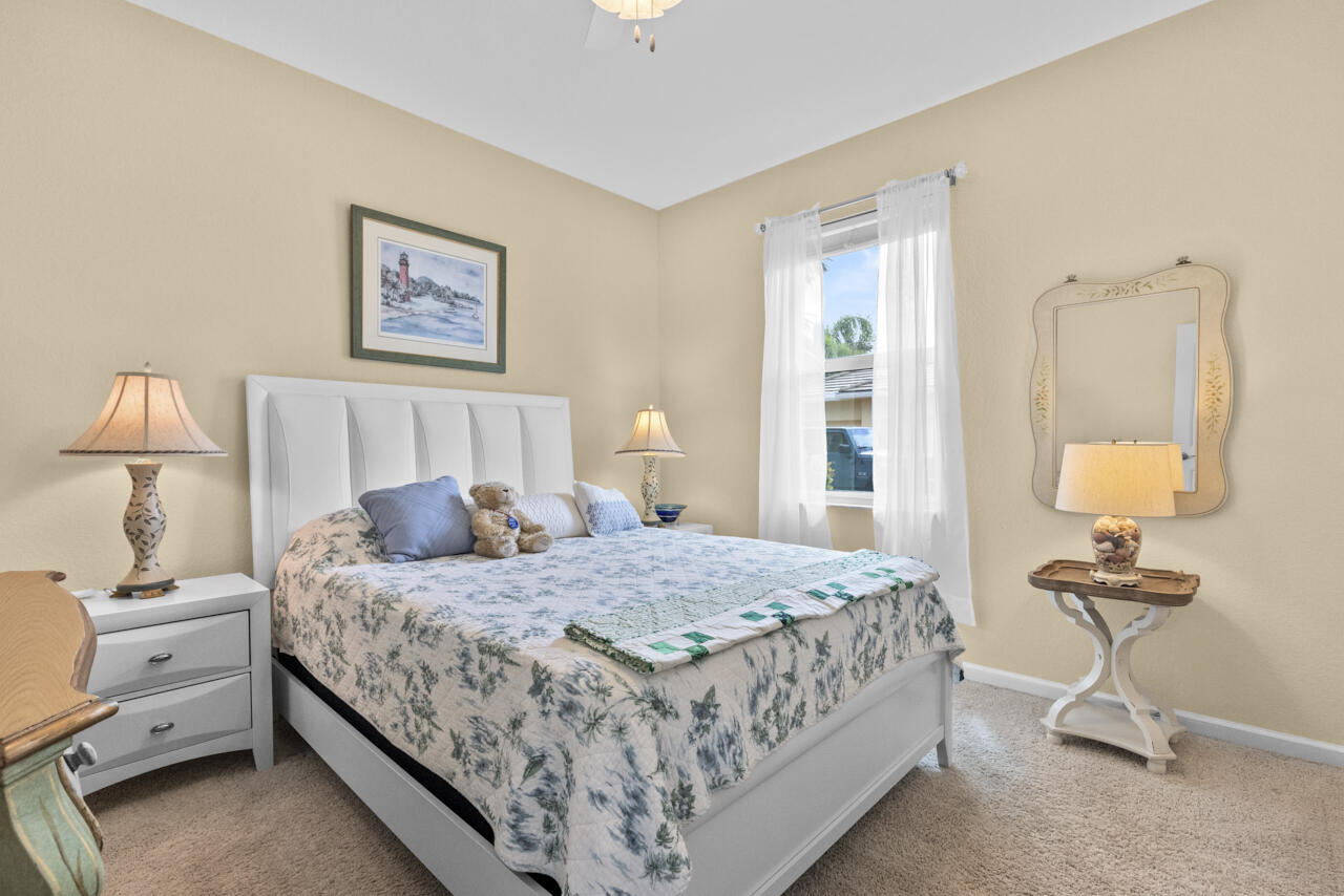 2190 Northwest Dalea Way Stuart, FL 34994 - Photo 20 of 31 a bedroom with a bed and a lamp on table