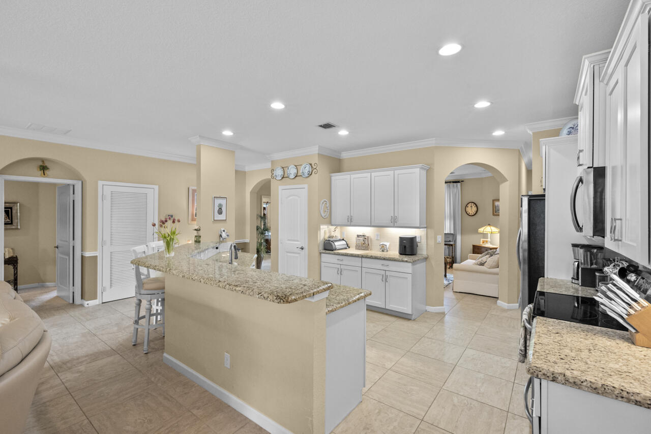 2190 Northwest Dalea Way Stuart, FL 34994 - Photo 8 of 31 a large white kitchen with stainless steel appliances kitchen island granite countertop a large counter top and sink