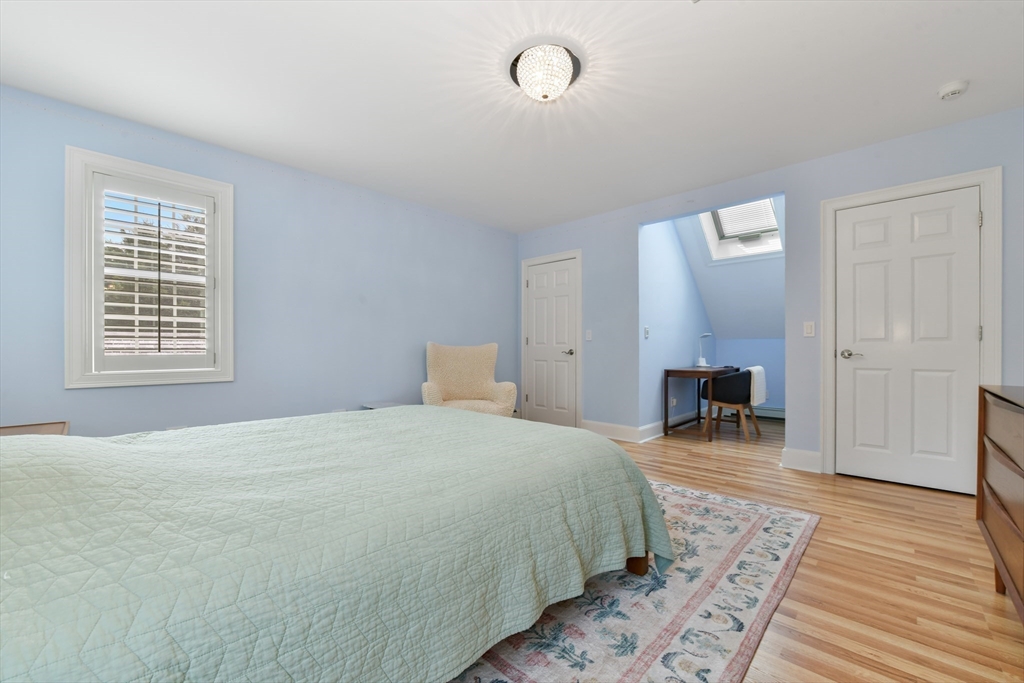 1460 South County Road Barnstable, MA 02655 - Photo 20 of 40 a bedroom with a bed a table and wooden floor
