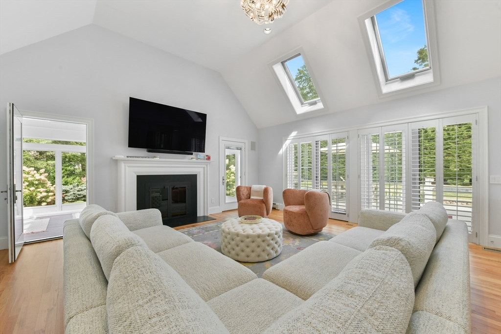 1460 South County Road Barnstable, MA 02655 - Photo 6 of 40 a living room with furniture a flat screen tv and a fireplace