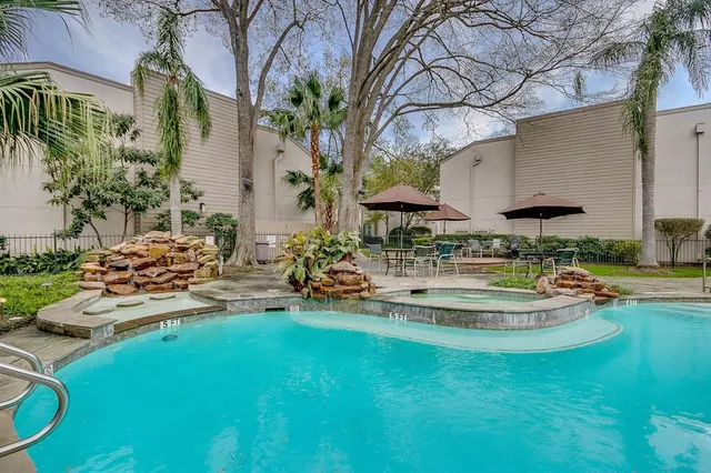 a view of a backyard with plants and swimming pool