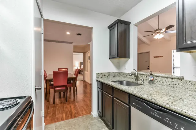 a bathroom with a granite countertop sink a toilet and a mirror