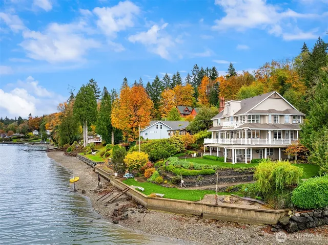 a view of a white house with a yard and potted plants