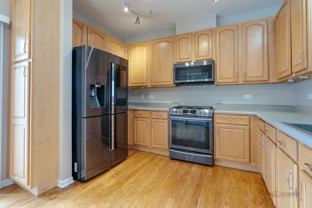 a kitchen with stainless steel appliances a refrigerator and cabinets