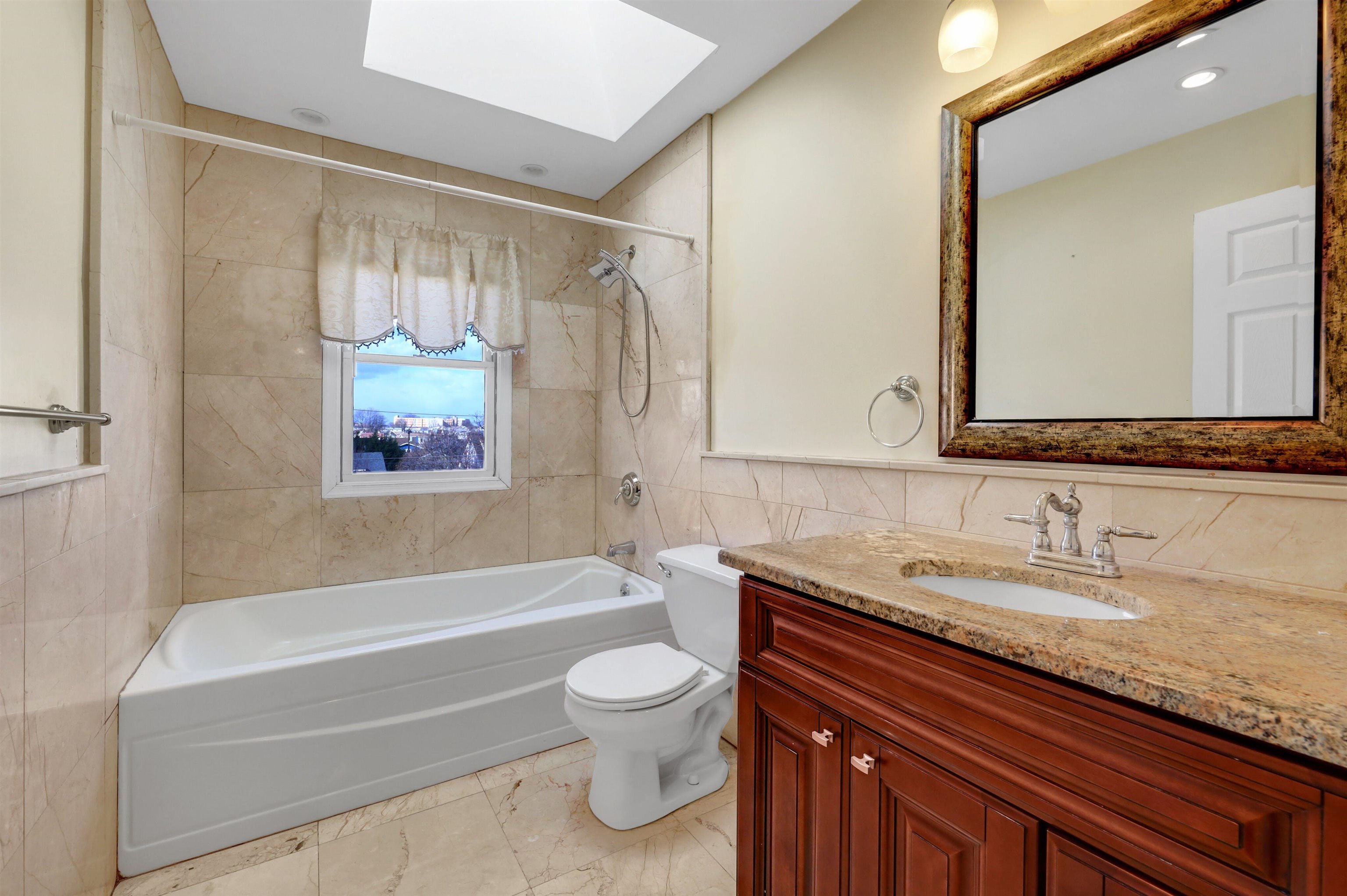 733 Chestnut Street, Unit A Secaucus, NJ 07094 - Photo 14 of 20 a bathroom with a granite countertop sink a toilet a mirror and bathtub