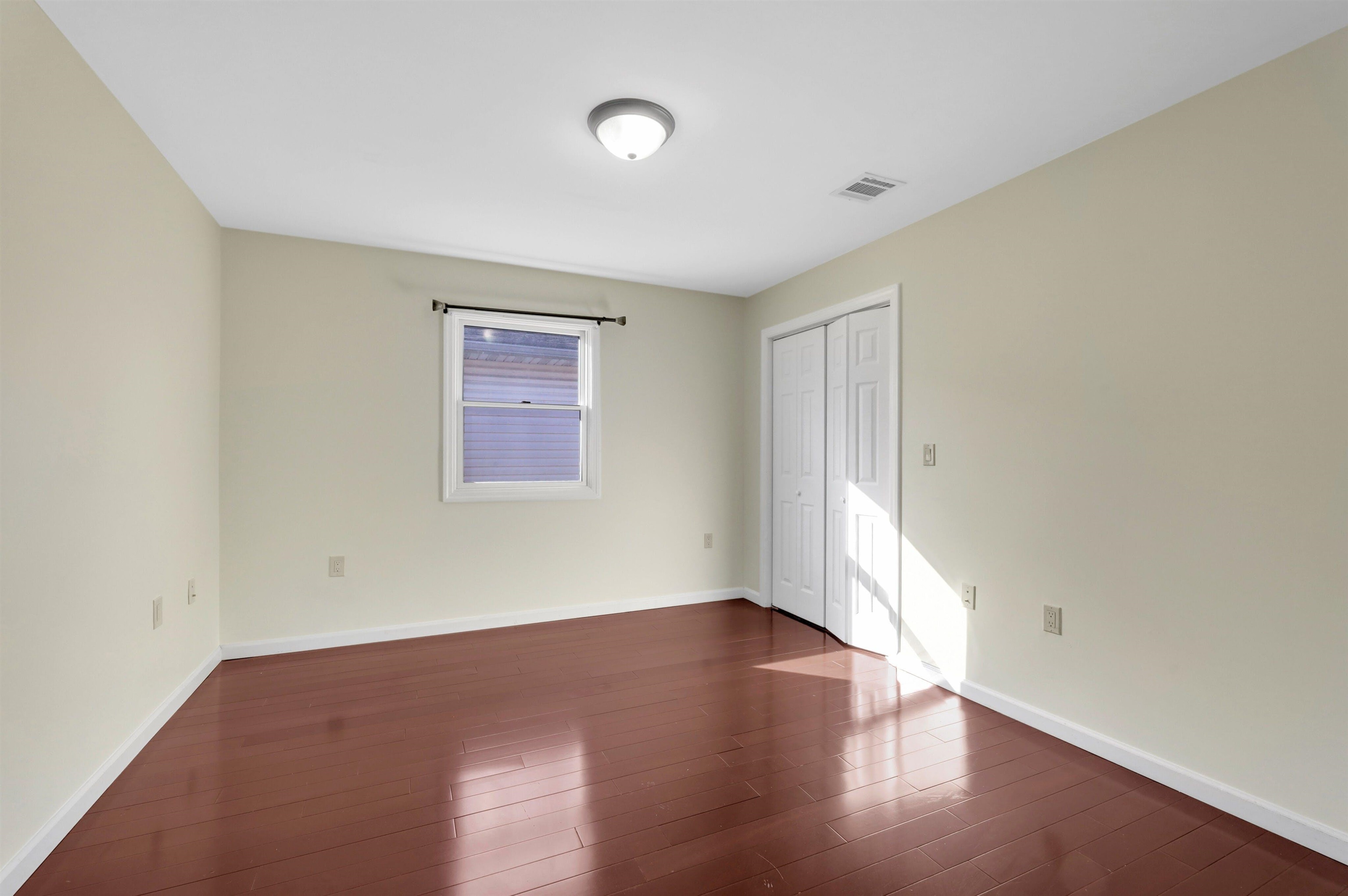 733 Chestnut Street, Unit A Secaucus, NJ 07094 - Photo 15 of 20 an empty room with wooden floor and windows