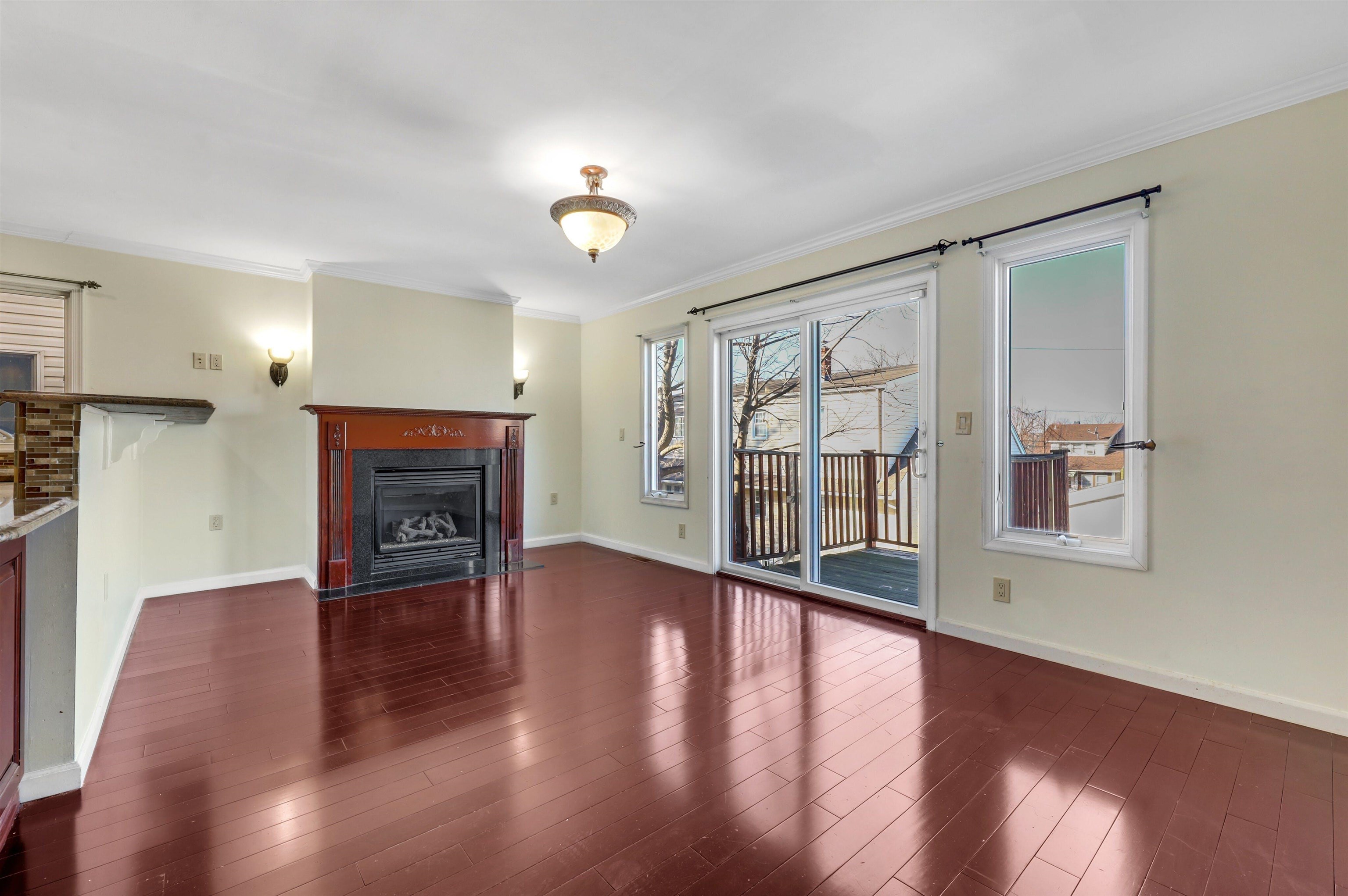 733 Chestnut Street, Unit A Secaucus, NJ 07094 - Photo 7 of 20 an empty room with wooden floor and a fireplace