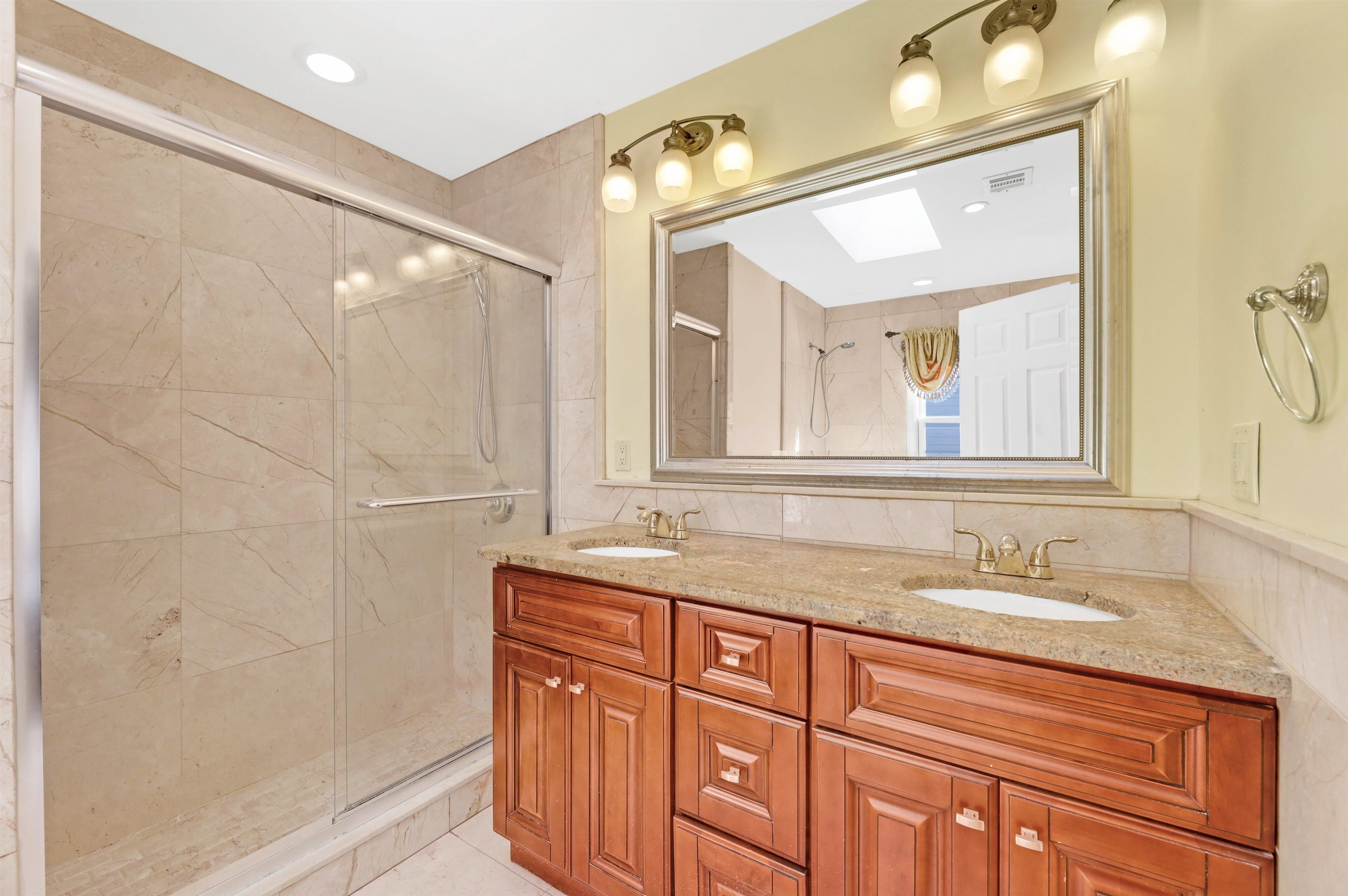 733 Chestnut Street, Unit A Secaucus, NJ 07094 - Photo 9 of 20 a bathroom with a granite countertop sink a mirror and a shower