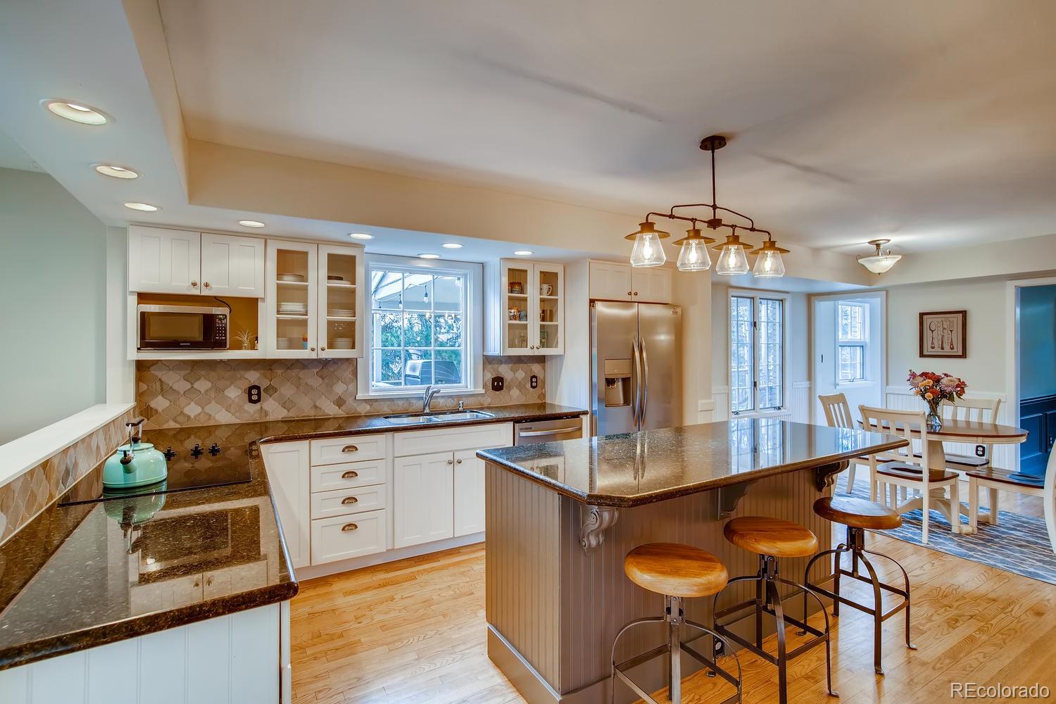 1894 La Quinta Circle Evergreen, CO 80439 - Photo 11 of 36 a kitchen with stainless steel appliances granite countertop a stove top oven a sink dishwasher and cabinets with wooden floor