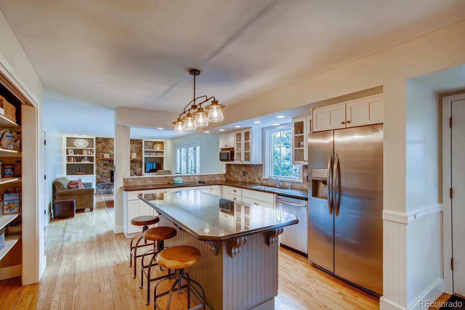 1894 La Quinta Circle Evergreen, CO 80439 - Photo 12 of 36 a kitchen with stainless steel appliances granite countertop a table chairs and a refrigerator