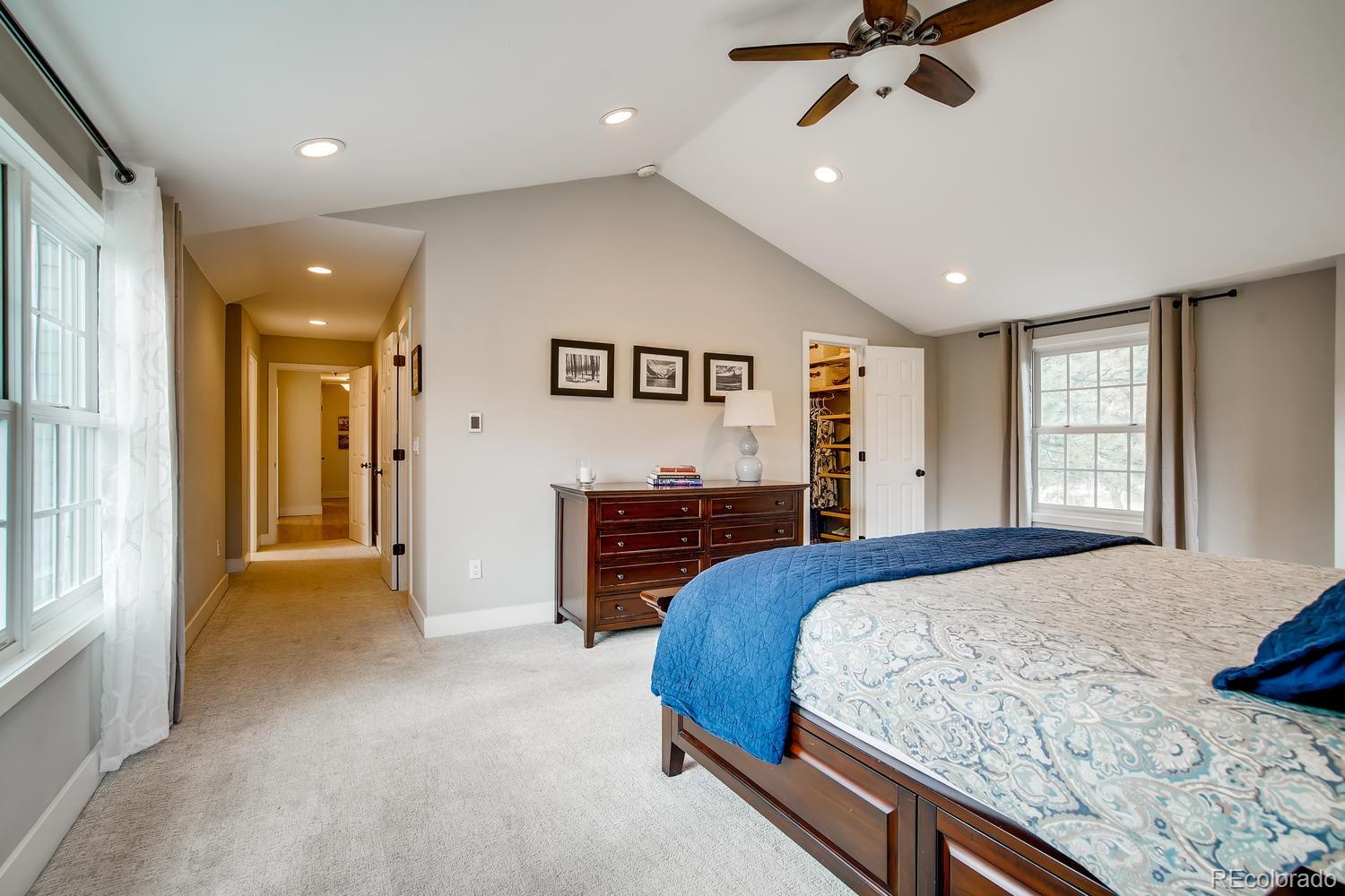 1894 La Quinta Circle Evergreen, CO 80439 - Photo 20 of 36 a spacious bedroom with a large bed and a chandelier