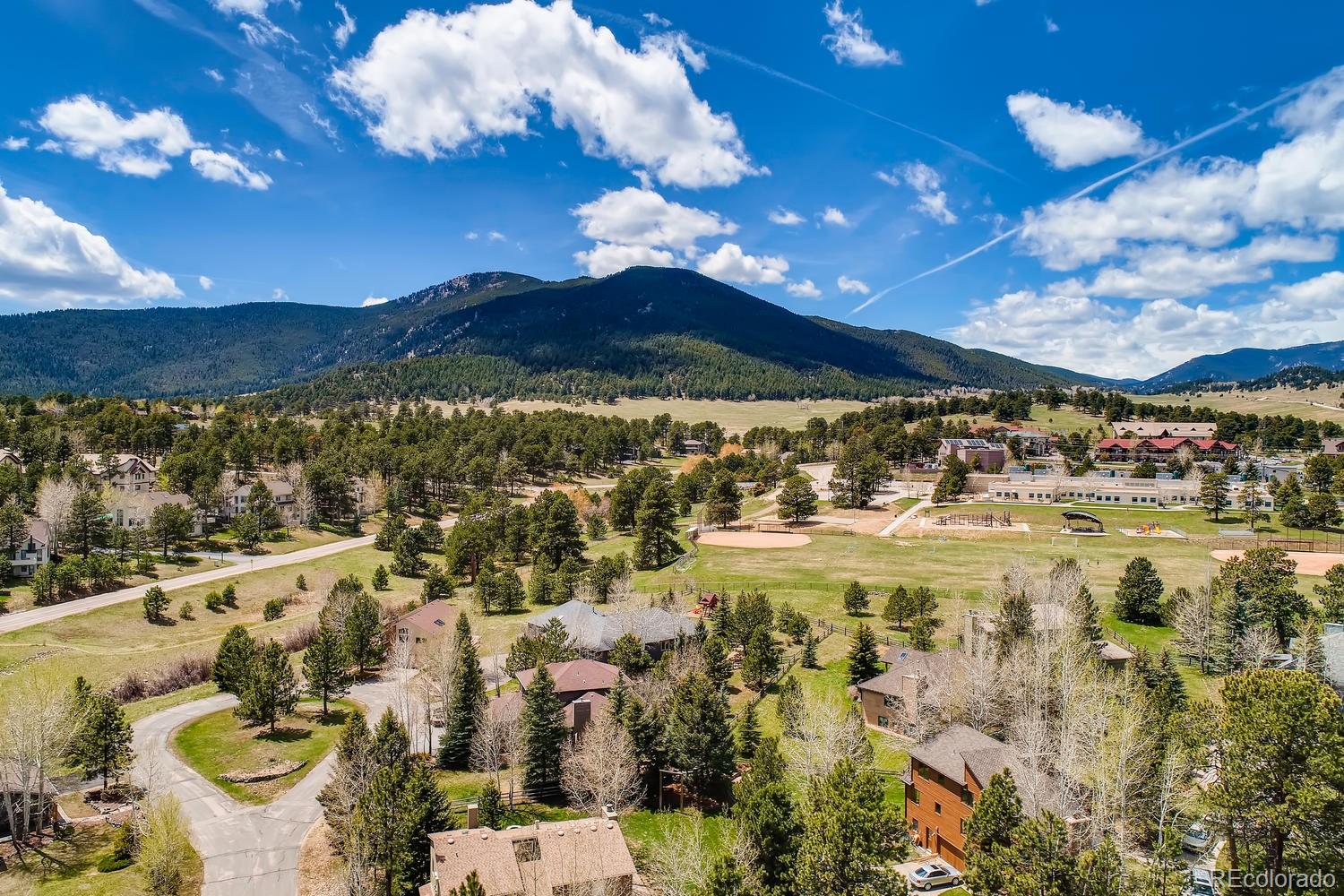 1894 La Quinta Circle Evergreen, CO 80439 - Photo 36 of 36 a view of a swimming pool with a table chairs and a fire pit
