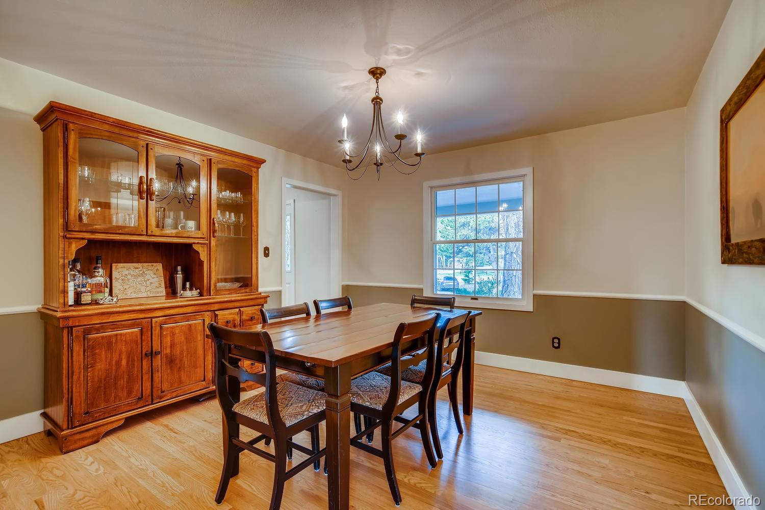 1894 La Quinta Circle Evergreen, CO 80439 - Photo 10 of 36 a dining room with wooden floor a chandelier a wooden table and chairs