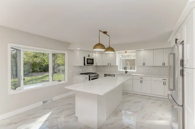 a kitchen with white cabinets and white appliances