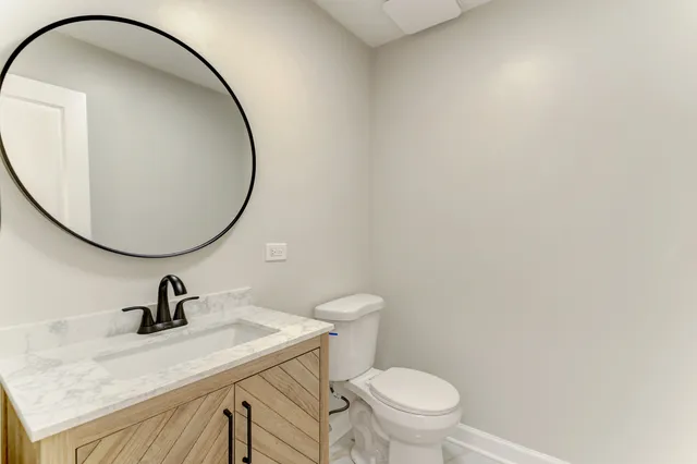 a bathroom with a sink a toilet and a mirror