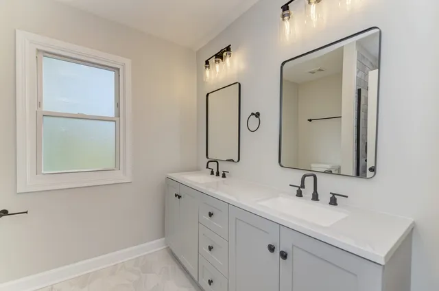 a bathroom with double vanity sink and a mirror