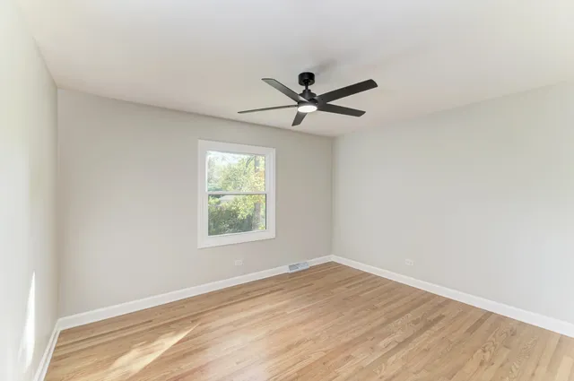 a view of a big room with wooden floor and a window