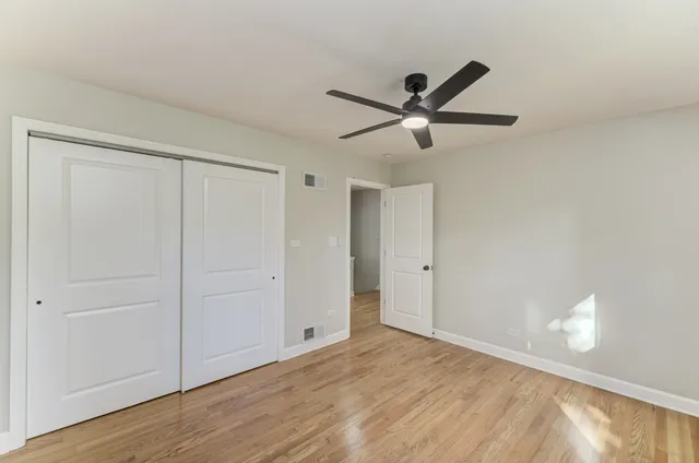 a view of a livingroom with a ceiling fan & hardwood floor