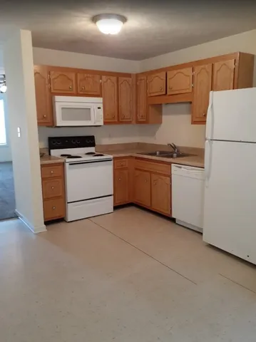 a kitchen with stainless steel appliances granite countertop a refrigerator sink and stove