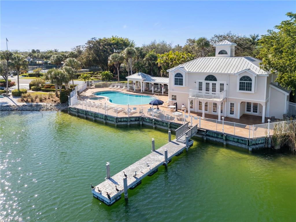 2662 Aft Avenue Naples, FL 34109 - Photo 18 of 26 Back of house with a patio, a balcony, a water view, a metal roof, and view of wooded area