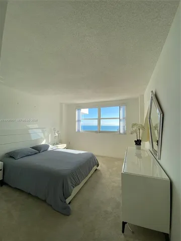 a bedroom with a bed and a dresser next to it