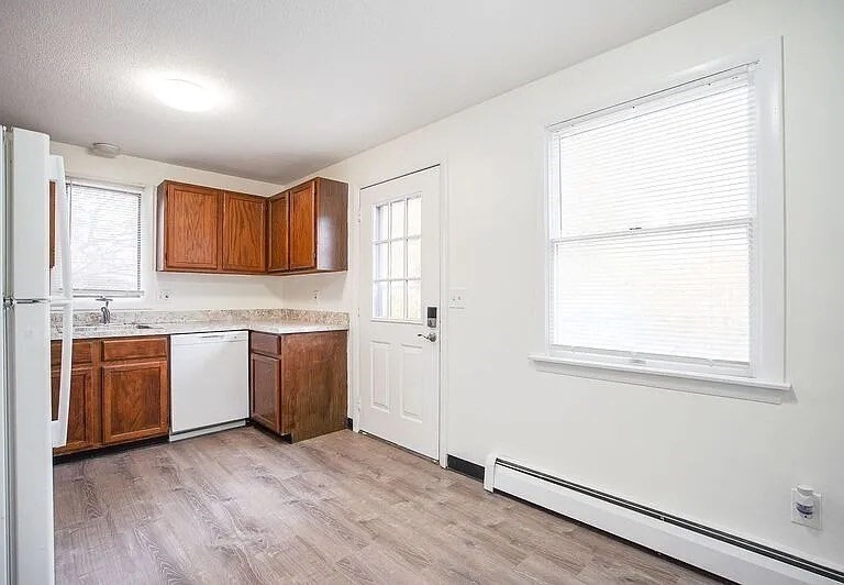 878-880 St James Avenue Springfield, MA 01104 - Photo 5 of 17 a kitchen with granite countertop wooden cabinets a sink and a window
