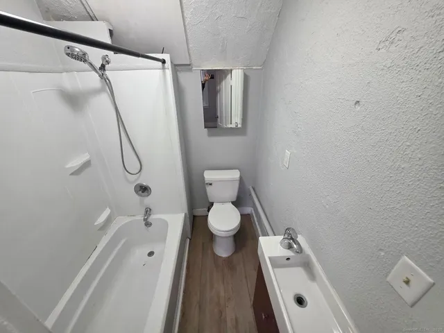 a bathroom with a sink a toilet and shower