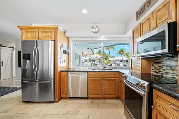 a kitchen with stainless steel appliances granite countertop a refrigerator oven a sink and dishwasher