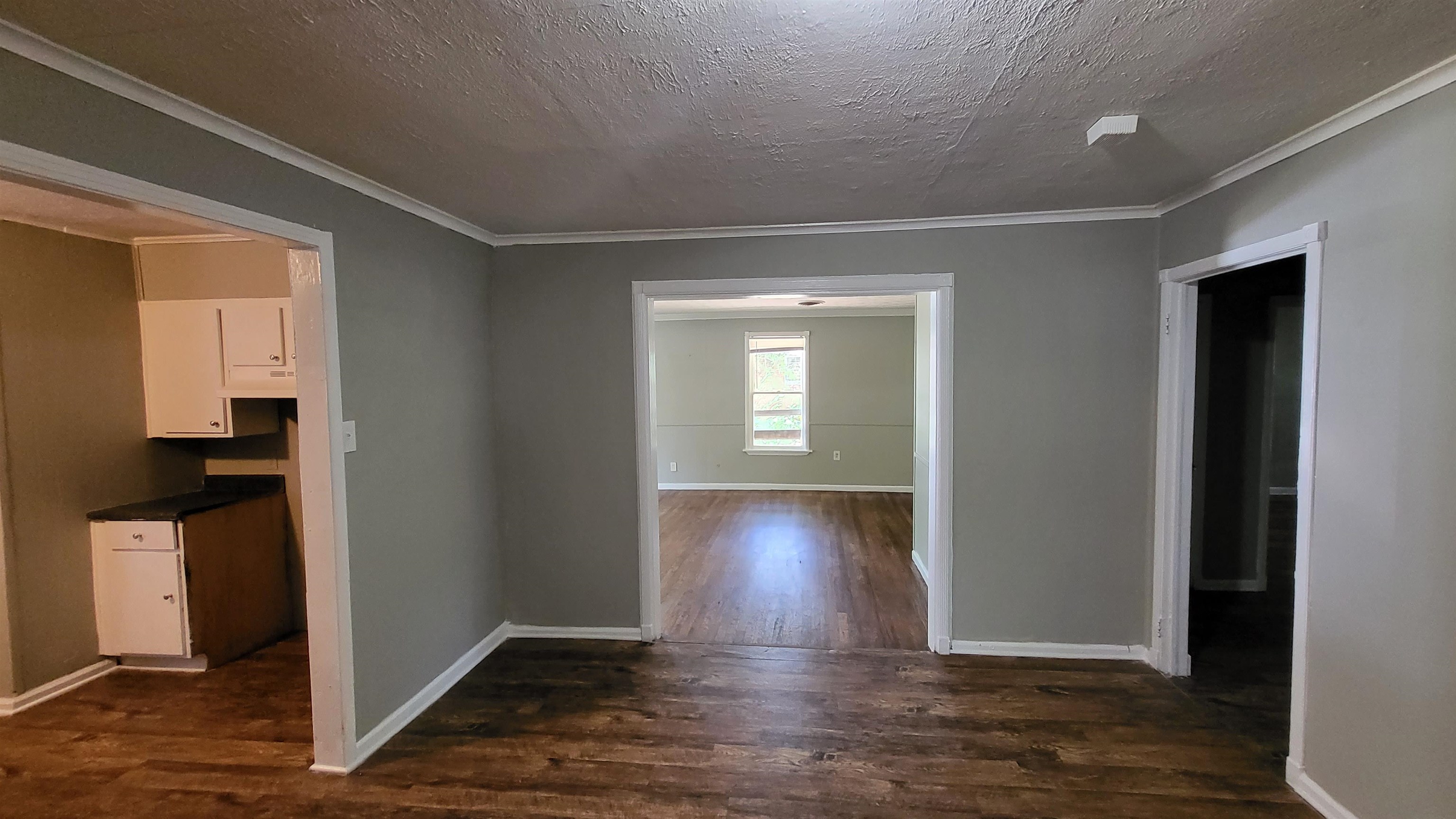 3758 Elliston Road Memphis, TN 38111 - Photo 2 of 6 Corridor featuring crown molding, dark wood-type flooring, and a textured ceiling