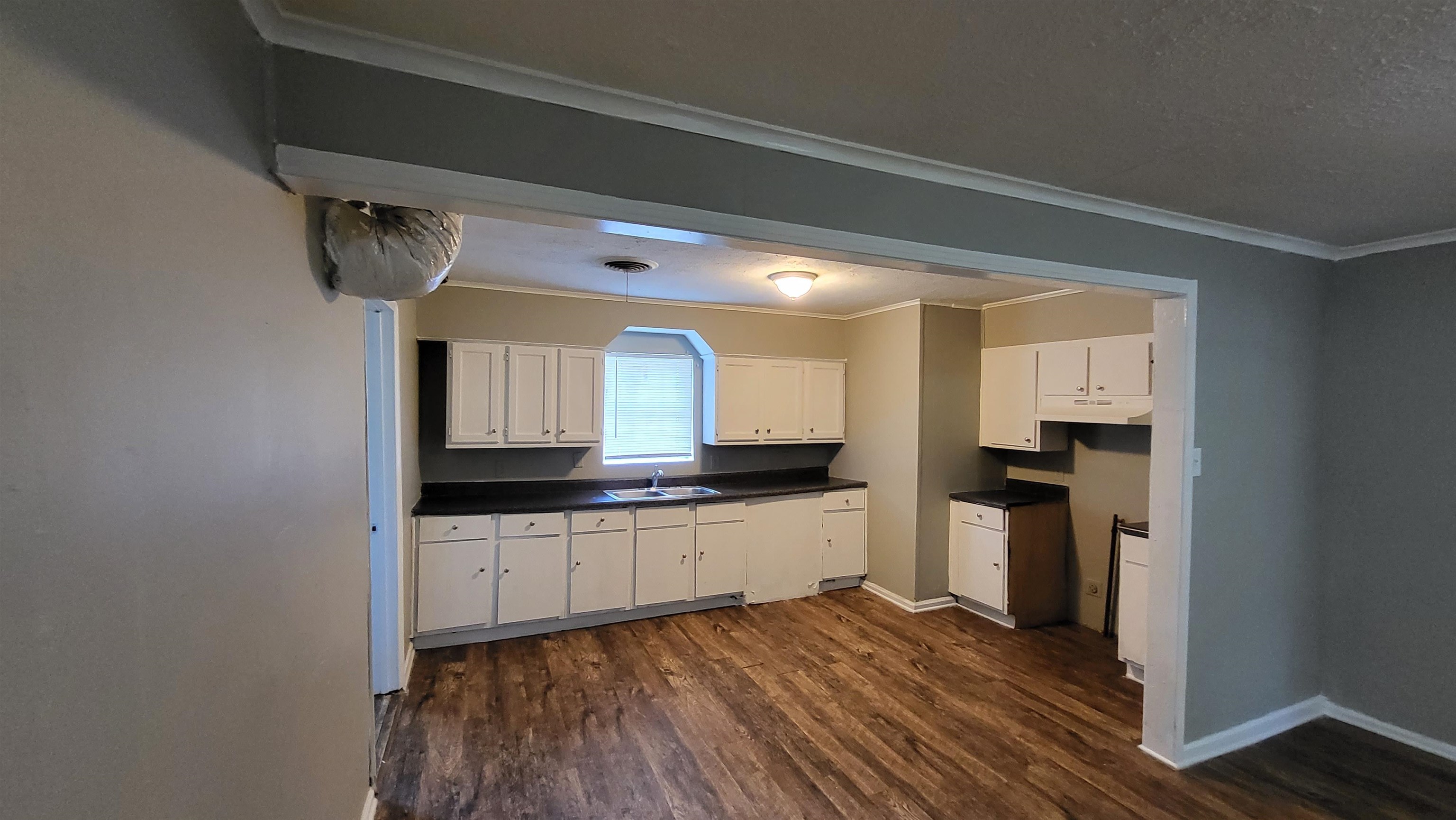 3758 Elliston Road Memphis, TN 38111 - Photo 6 of 6 Kitchen with crown molding, white cabinetry, sink, and dark wood-type flooring