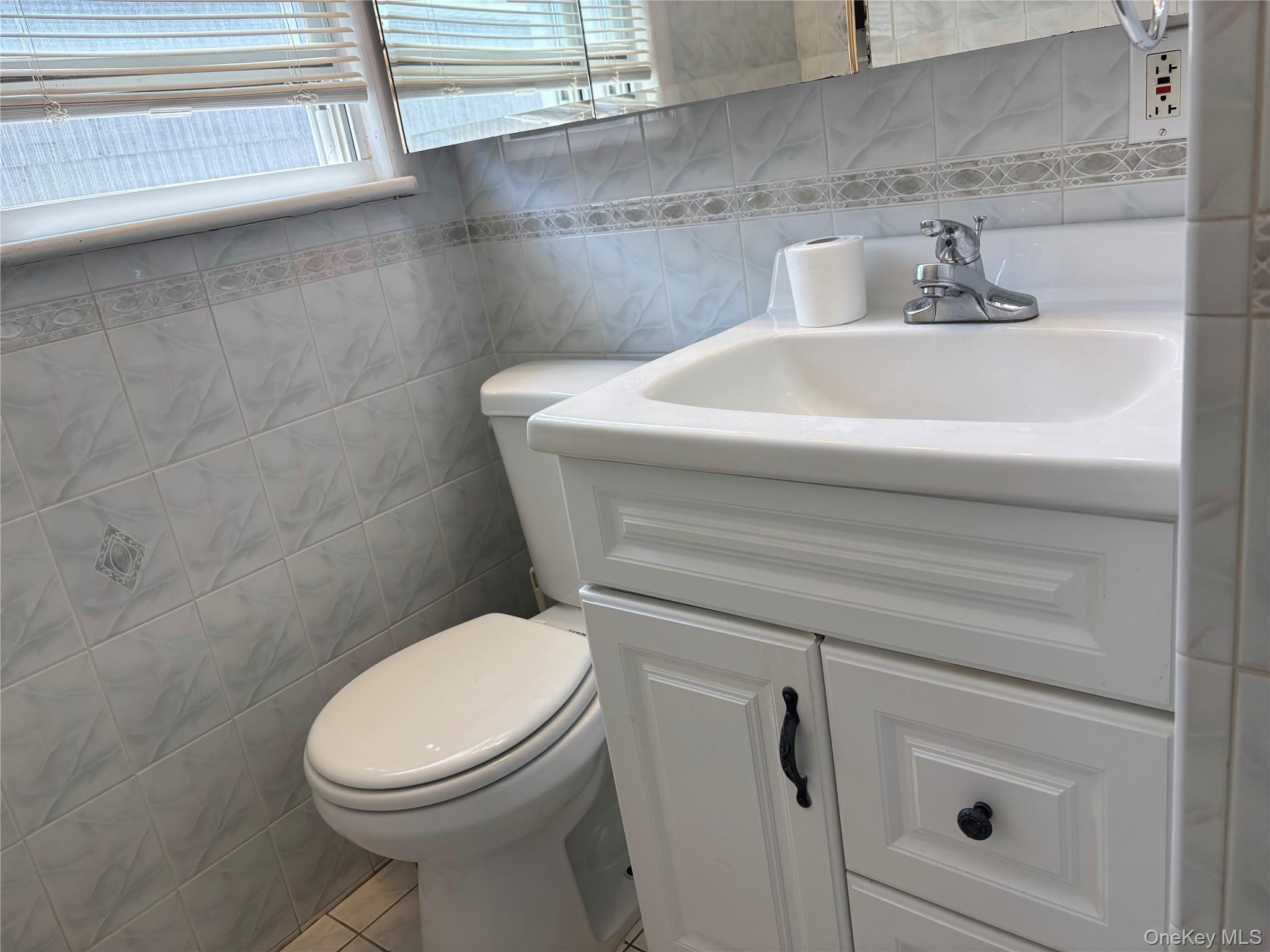 104-18 216th Street Queens, NY 11429 - Photo 23 of 49 Bathroom with tile walls, vanity, and tile patterned flooring
