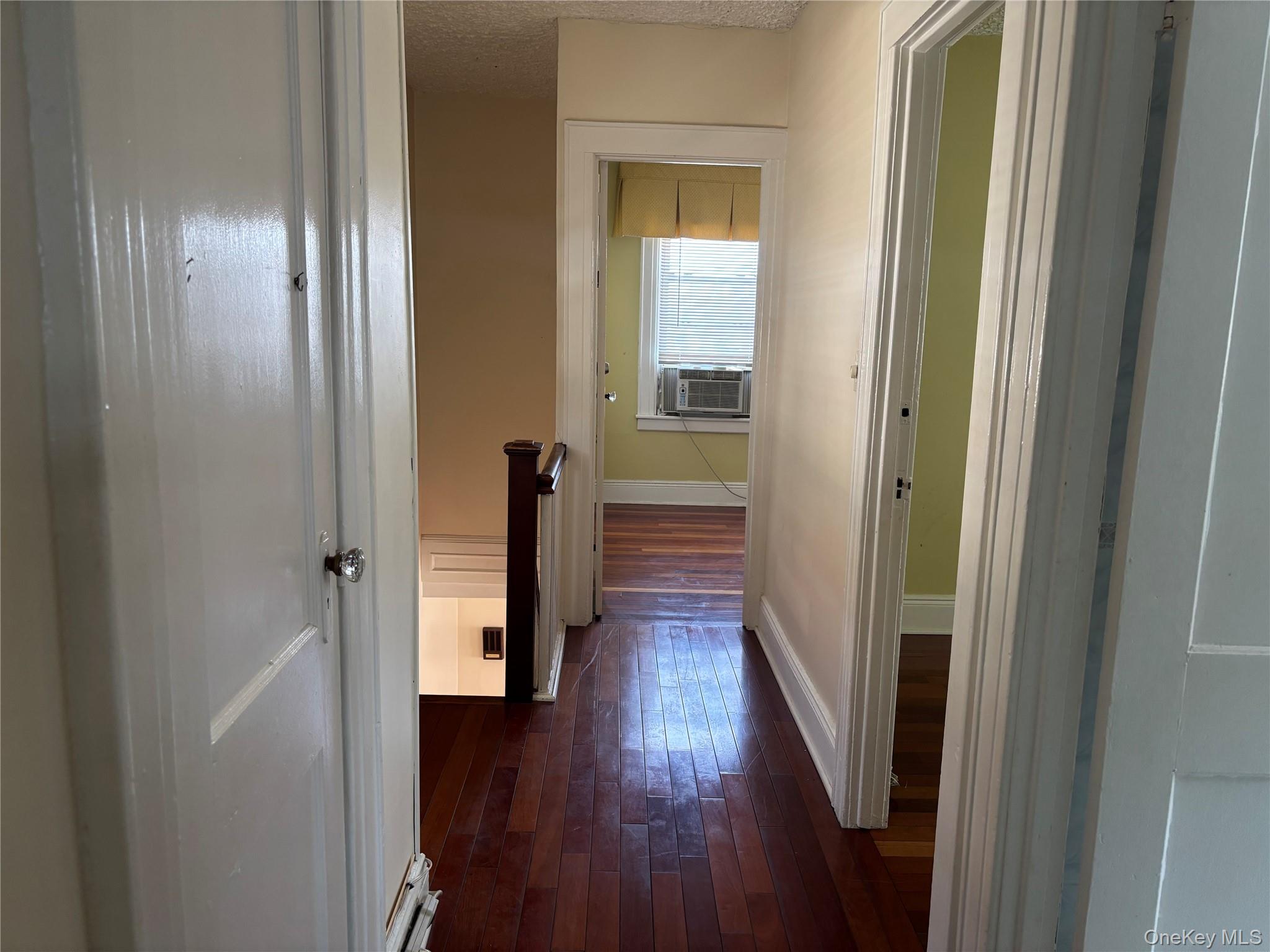 104-18 216th Street Queens, NY 11429 - Photo 30 of 49 Hall with dark wood finished floors and a textured ceiling