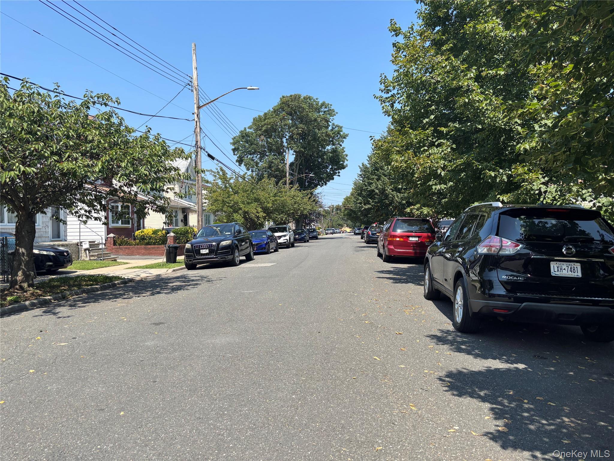 104-18 216th Street Queens, NY 11429 - Photo 49 of 49 View of asphalt road featuring street lighting, sidewalks, and curbs