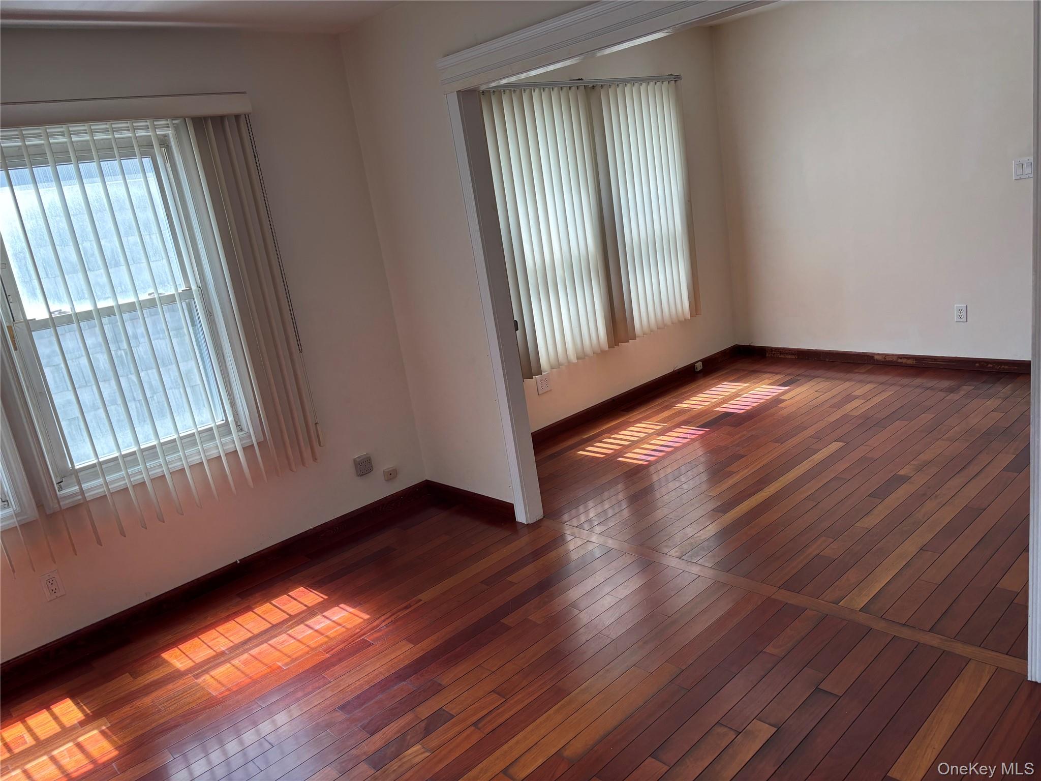 104-18 216th Street Queens, NY 11429 - Photo 7 of 49 Spare room with dark wood-style flooring and baseboards