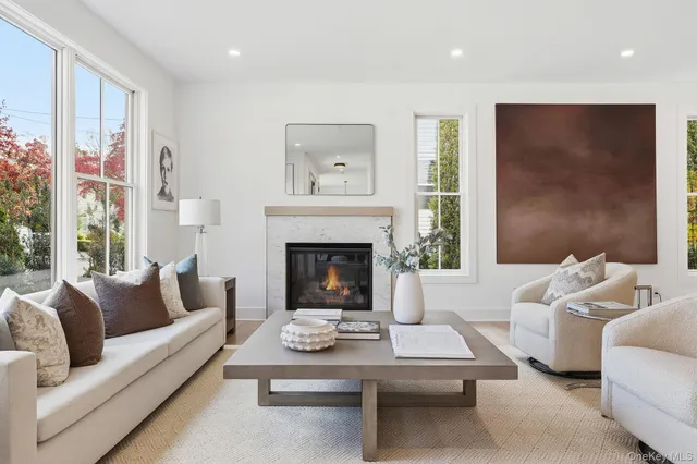 a living room with furniture a large window and a fireplace