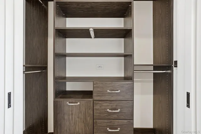 a view of walk in closet with clothes