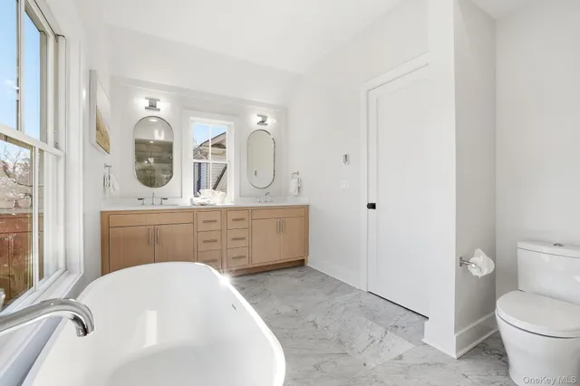a large white tub sitting in front of a window