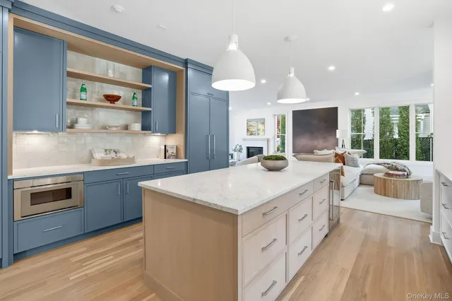 a kitchen with a sink a large window and a wooden floor