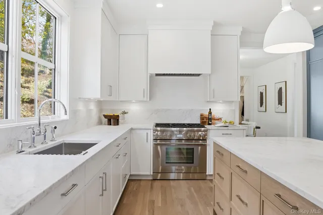 a kitchen with a sink a counter top space stainless steel appliances and windows