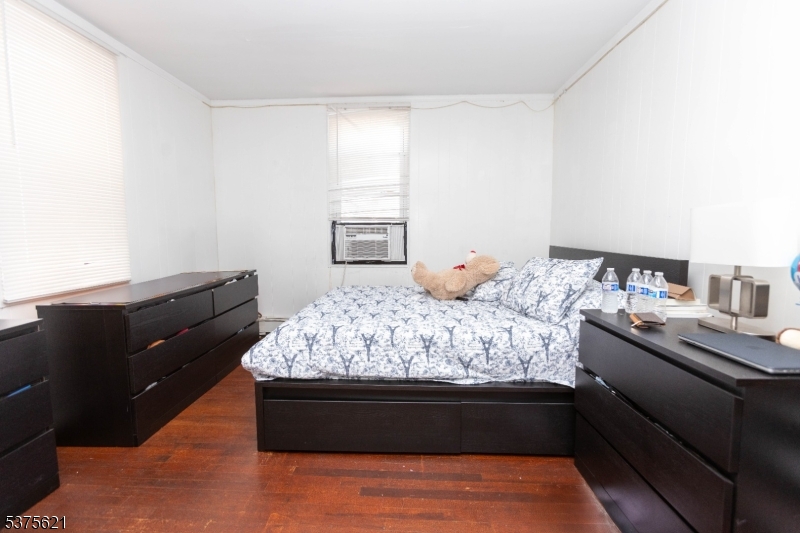 622 North 9th Street Newark, NJ 07107 - Photo 7 of 24 a bed sitting in a bedroom next to a window with dresser